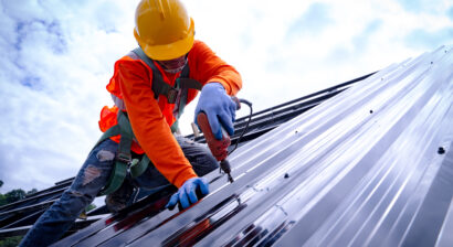 roofer working on construction of metal roof
