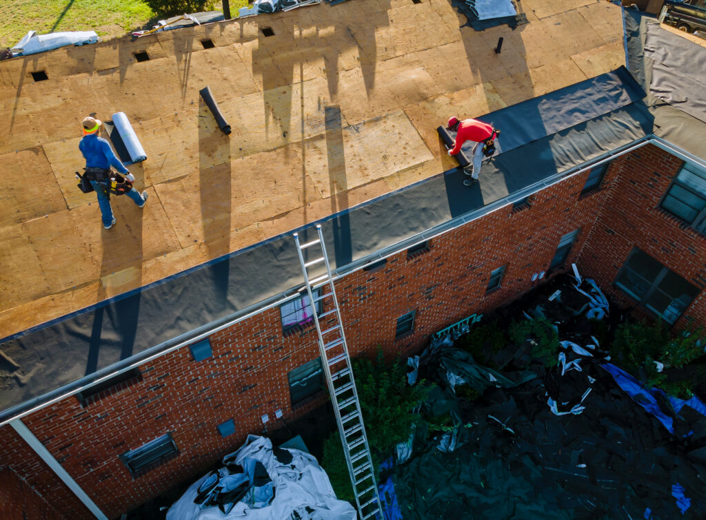 workers removing old shingles on a roof