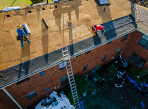 workers removing old shingles on a roof
