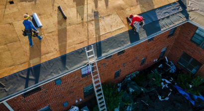 workers removing old shingles on a roof