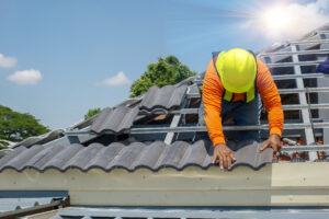 roof repair worker with gloves on replacing tiles