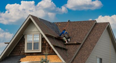 a worker moving along roof for next repair