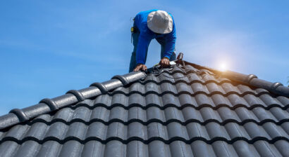 roof repair worker replacing tiles