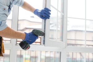 handyman adjusting white window indoors