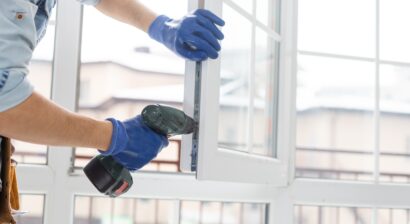 handyman adjusting white window indoors