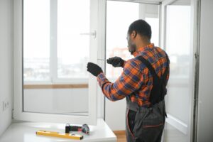 worker in overalls installing or adjusting window