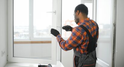 worker in overalls installing or adjusting window