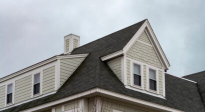 dormer windows and a sloped shingled roof on a home