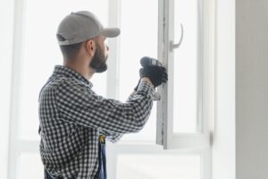 service man installing window with screwdriver