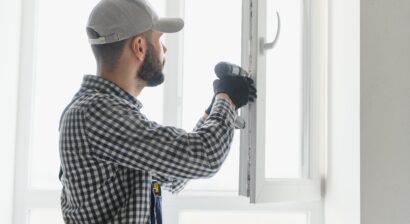 service man installing window with screwdriver