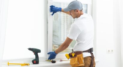 worker in gloves adjusting window