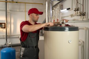 man wearing red shirt fixing a water heater