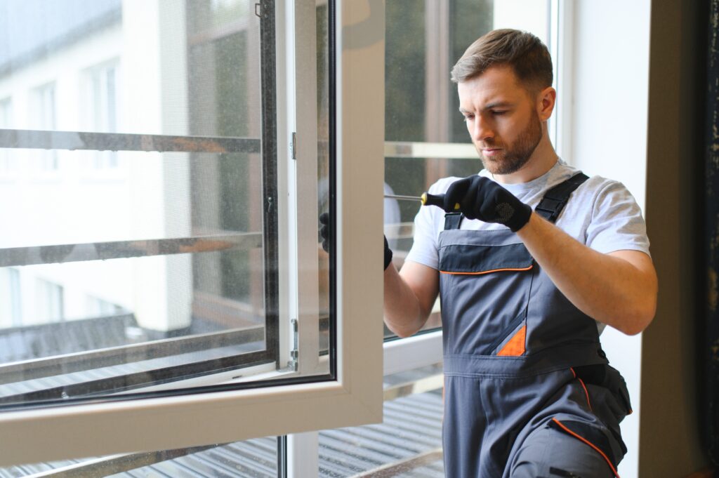 worker in overalls installing windows