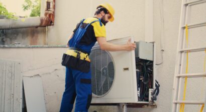 worker starting service on malfunctioning outdoor ac unit