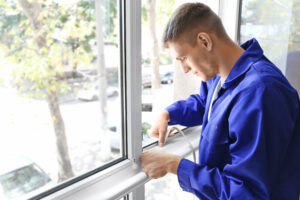 worker putting sealing tape on window of house