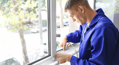 worker putting sealing tape on window of house