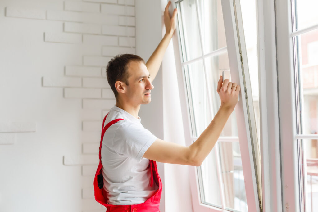 construction worker installing new window in house