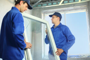 two workers in blue clothes set a new window