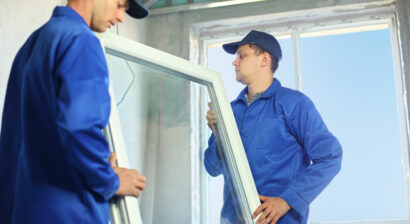 two workers in blue clothes set a new window