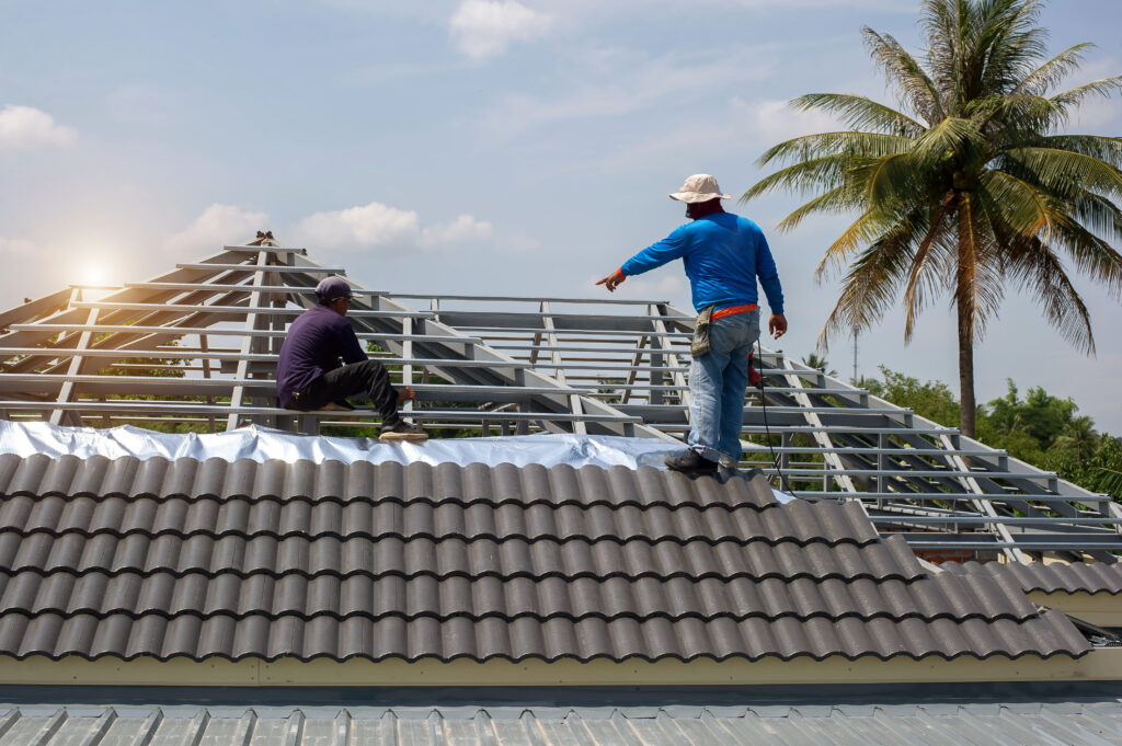 roof repair worker with gloves replacing gray tiles