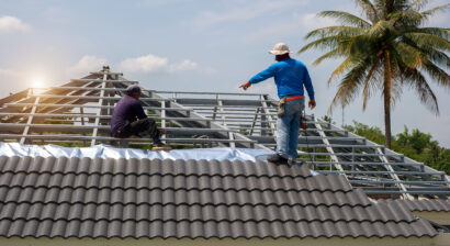 roof repair worker with gloves replacing gray tiles