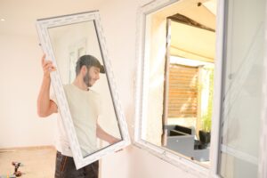 young professional man installing new window in home