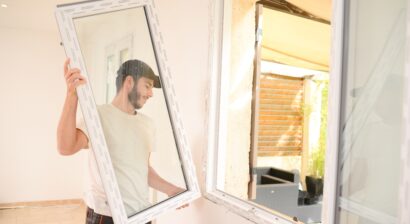 young professional man installing new window in home