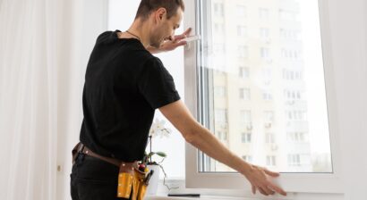 worker in gloves adjusting window for installation