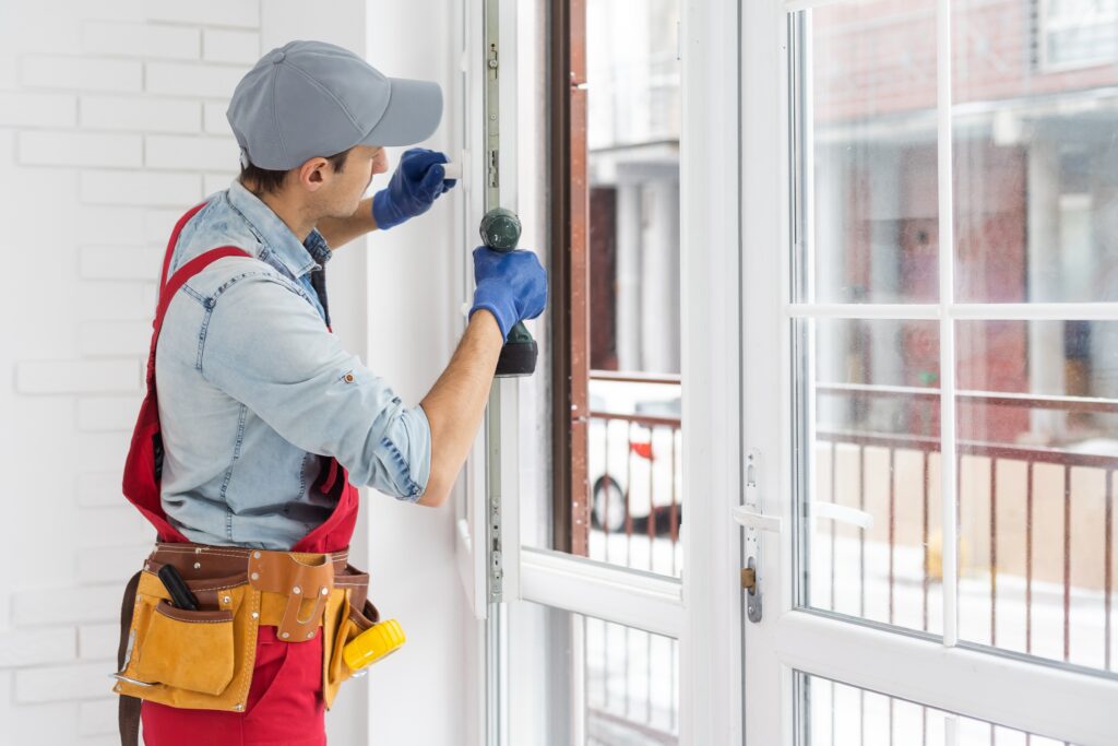 construction worker fixing window in house