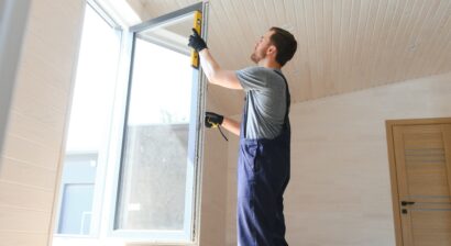 construction worker installing new window in house