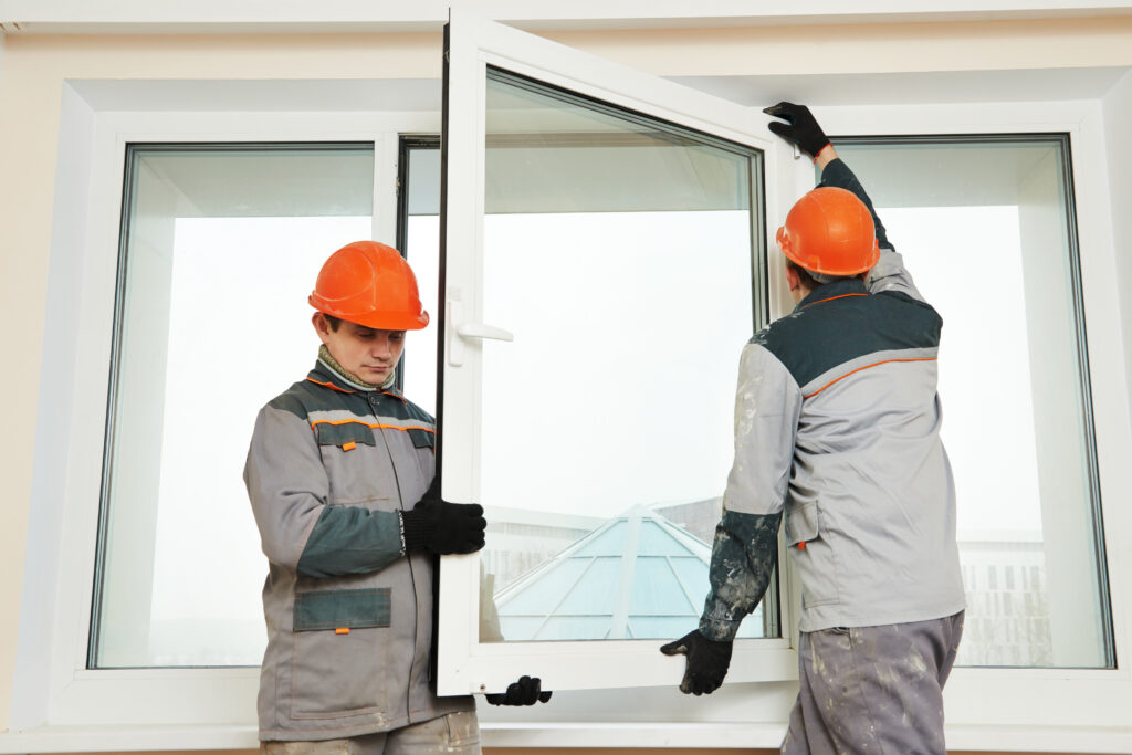 two male builders working on a window installation
