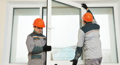 two male builders working on a window installation