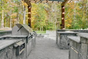 inviting partially covered outdoor patio with stone kitchen