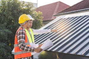 two men in construction gear inspecting roof