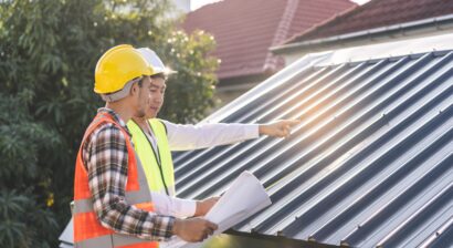 two men in construction gear inspecting roof