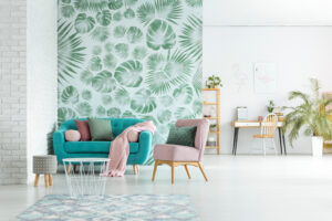 pink arm chair and blue couch with blanket in bright room