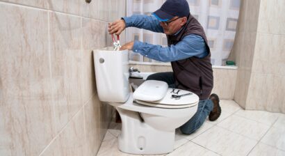 professional plumber repairing a toilet