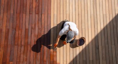 overhead view of workman staining wood outside