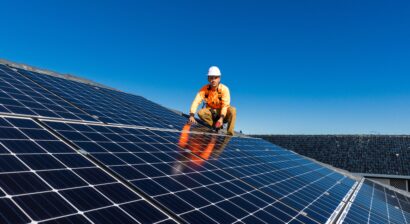 solar panel technician with drill installing panels
