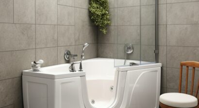 walk in tub with gray tile on surrounding walls