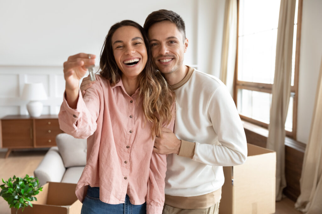 happy young couple holding keys to new home