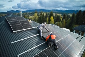 electricians building solar panels onto roof of house