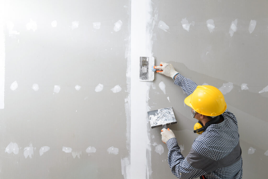 construction worker in uniform and hardhat working on interior