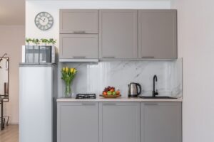 a small modern kitchen with grey cabinets