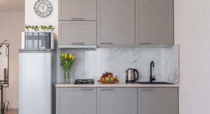 a small modern kitchen with grey cabinets