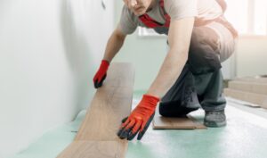 professional worker installing flooring with gloves on