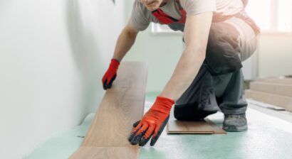professional worker installing flooring with gloves on