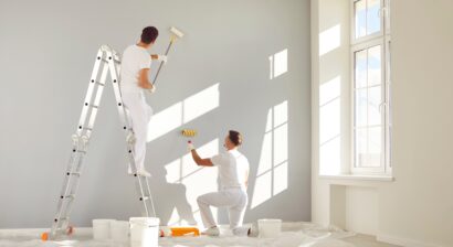 two male workers painting the interior of a home