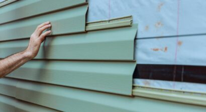 contractor installing vinyl siding on home