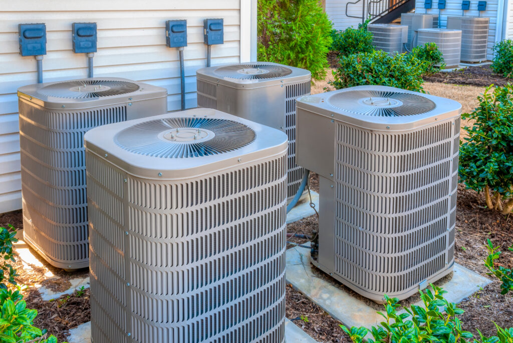 horizontal shot of four air conditioners outside home